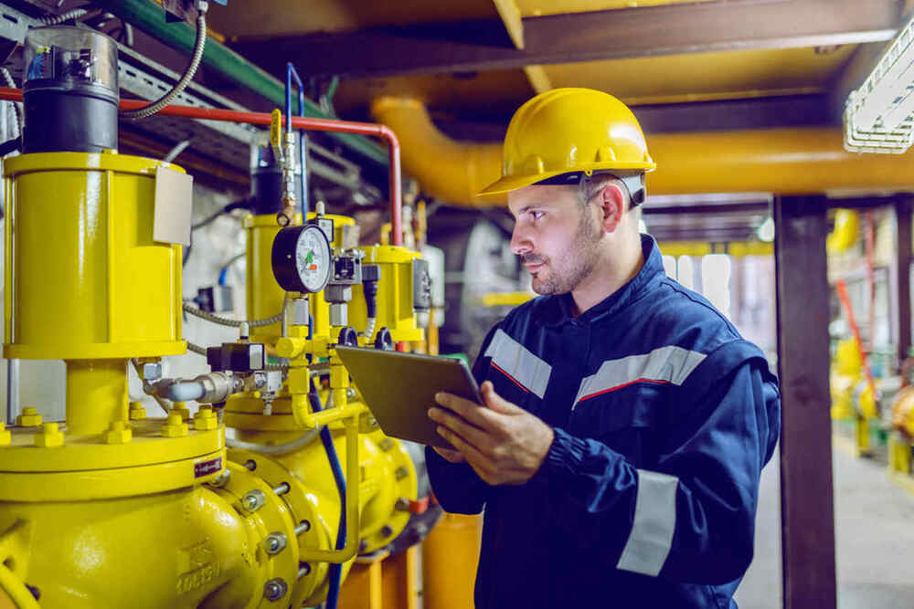funcionário de indústria realiza manutenção preventiva de equipamento
